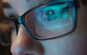 Person wearing glasses looking at a computer screen