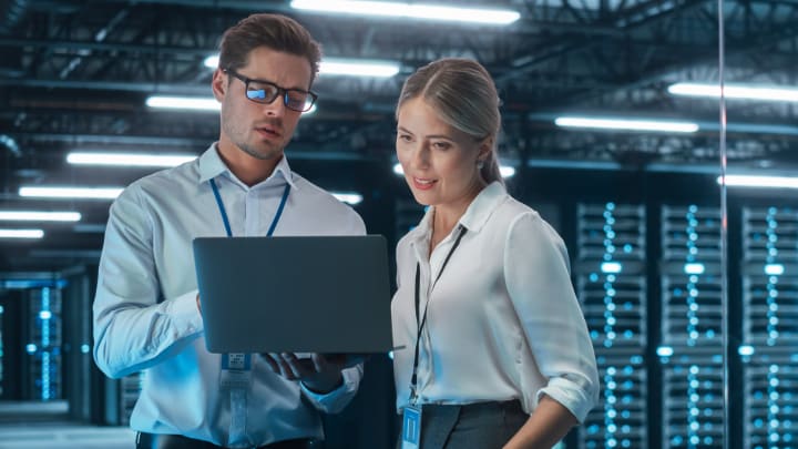 2 co-workers looking at a laptop