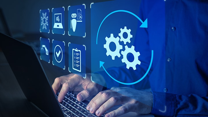 A person typing on a laptop, with various icons displayed on the screen, indicating active digital engagement