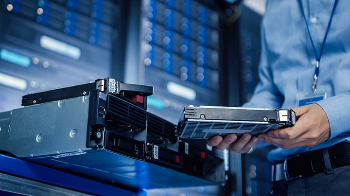 A person inserting a hard disk into the CPU