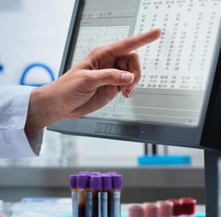 A person pointing at data on a screen